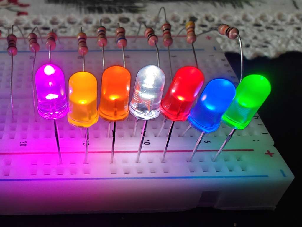 Multiple LEDs being tested on a breadboard with varying resistors.